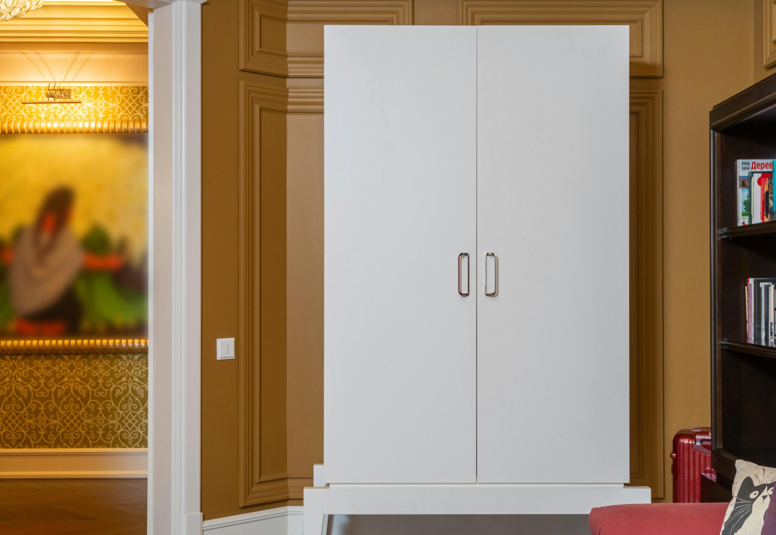 Sleek white wardrobe in a luxurious, modern interior with elegant wood paneling and decor.
